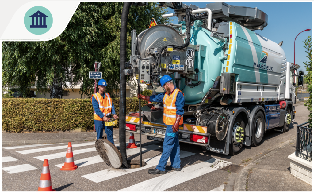 Découchage d'une canalisation dans une rue par des ouvriers avec un camion